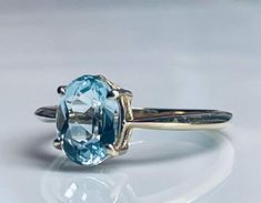 an oval blue topaz ring on a white surface