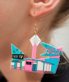 Indulge in a nostalgic trip down memory lane with these 70s Retro Relic828 Kitschy Motel Earrings. Inspired by the quirky and colorful motels of the era, these earrings feature a unique design that captures the retro charm of the 70s. Crafted from lightweight acrylic, these earrings offer comfort without compromising on style. The hooks are made of stainless steel, coated in 18k gold for a touch of luxury, and are nickel-free to ensure a comfortable wearing experience. Product Details: Size: Eac Retro Multicolor Drop Earrings, Retro Dangle Jewelry, Retro Multicolor Nickel-free Jewelry, Multicolor Nickel-free Retro Jewelry, Retro Dangle Earrings, Retro Pink Nickel-free Jewelry, 70s Nostalgia, Retro Earrings, Retro Earring