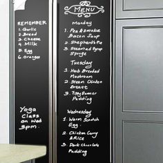 a blackboard menu on the side of a wall next to a table and chairs