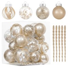 a bunch of ornaments are in a clear box with gold trimmings on it