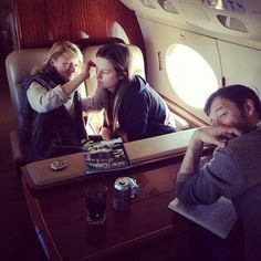 three people sitting on an airplane looking in the mirror