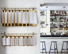 a bar with chairs and menus hanging on the wall next to a bar counter