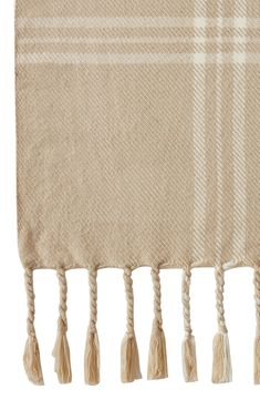 a tan and white plaid blanket with tassels