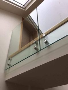 a glass balcony with skylight above it and metal brackets on the railings below