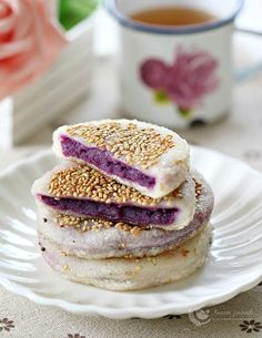 a stack of food sitting on top of a white plate next to a cup of tea