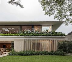 a house with plants growing on the roof and side walls that are covered in greenery