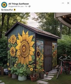 a garden shed with sunflowers painted on it's side and two bicycles parked next to it