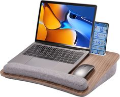 an open laptop computer sitting on top of a wooden desk next to a mouse pad