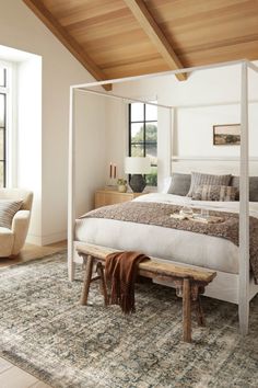 a bedroom with a canopy bed in the middle and an area rug on the floor