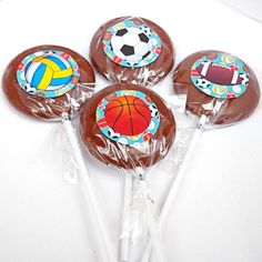 four chocolate lollipops with sports designs on them