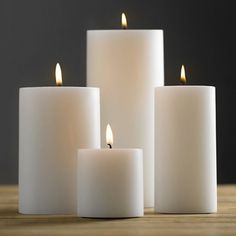 five white candles with one lit and the other turned on