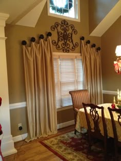 a dinning room table and chairs in front of a window