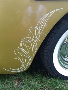 an old yellow car parked in the grass