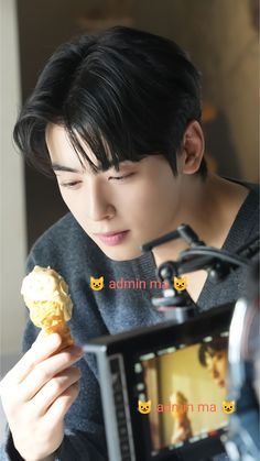 a young man holding food in front of a camera