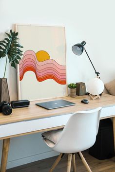 a white desk topped with a laptop computer sitting next to a lamp and potted plant