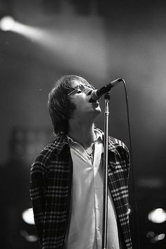 a man singing into a microphone while standing in front of a microphone on a stage