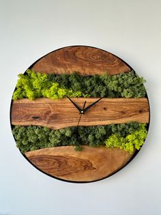 a wooden clock with green plants on it