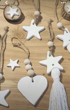 some white wooden ornaments are hanging on a string and wood planks with tassels attached to them