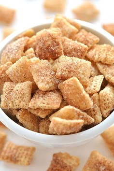 a white bowl filled with sugar cubes sitting on top of a table next to other small pieces of food