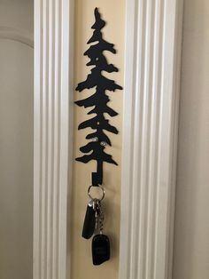 a door with a key chain hanging from it's side and a tree on the wall