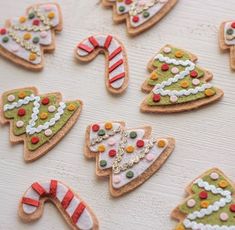 decorated cookies with candy canes and candies on a white table top, including christmas trees