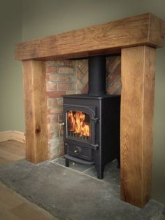 a wood burning stove sitting inside of a brick fireplace