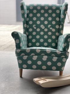 a green chair with white polka dots on it next to a wooden rocking toy horse