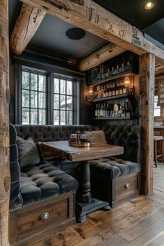 a room with a couch, table and some bottles on the shelves in it's corner