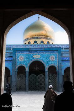 people standing in front of a blue building with a gold dome on it's roof