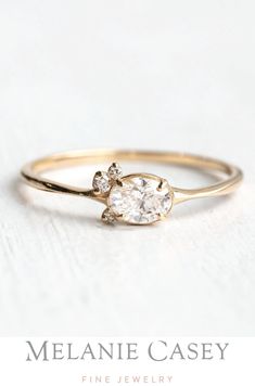 a gold engagement ring with two diamonds on the top and one diamond in the middle