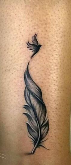 a black and white feather tattoo on the thigh