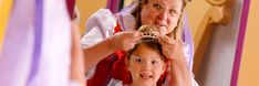 an older woman combing her daughter's hair in front of a mirror with ribbons