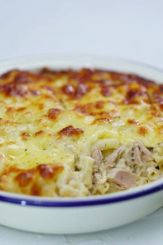 a casserole dish with meat and cheese in it on a white table top