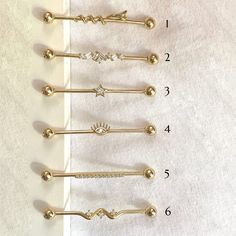 four different types of hair pins on a white sheet with numbers and symbols in the middle