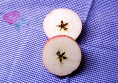 an apple cut in half sitting on top of a blue and white checkered cloth