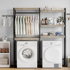 a washer and dryer in a room with clothes hanging on the racks above them