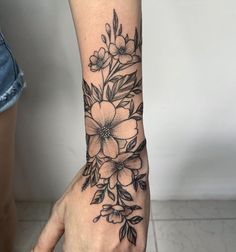 a woman's hand with a flower tattoo on it