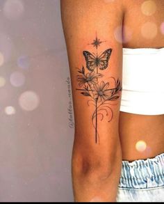 a woman's arm with a butterfly and flower tattoo on the left side of her leg