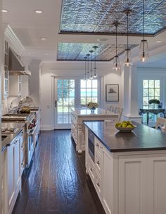 a large kitchen with wooden floors and white cabinets