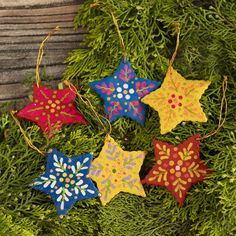 four brightly colored stars are hanging from the branches