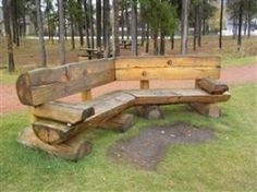 a wooden bench sitting in the middle of a forest filled with lots of green grass