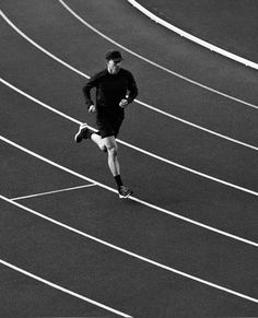 a man running on a track in black and white