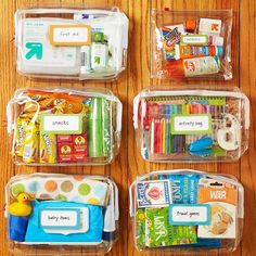 plastic containers filled with different types of school supplies on a wooden table in front of a wall