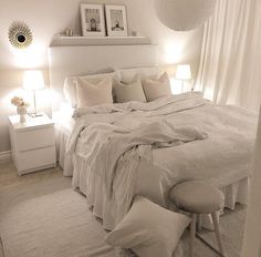 a bedroom with white bedding and pillows