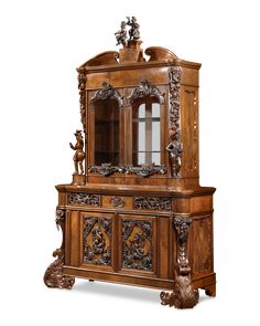 an old fashioned wooden cabinet with carvings on the front and sides, including a glass door