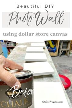 a hand holding a can of paint with the words, beautiful diy photo wall using dollar store canvass