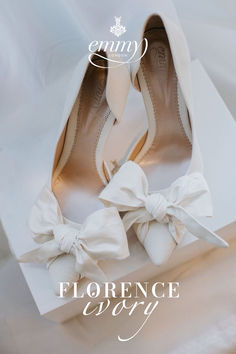 a pair of white shoes with bows on them