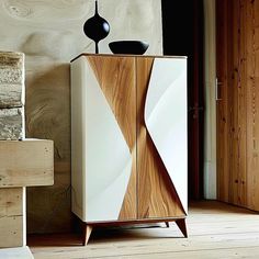 a white cabinet sitting next to a wooden floor in a room with wood paneling