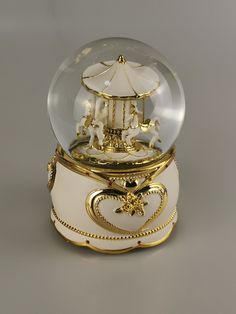 a snow globe with gold trimmings and an umbrella on top