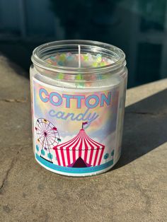 a candle that is sitting on the ground next to a water tank with a ferris wheel in it